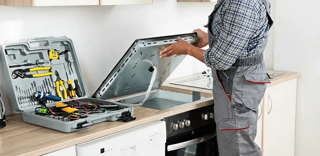 Handyman repairing a cooktop and checking wiring connections in Providence, RI