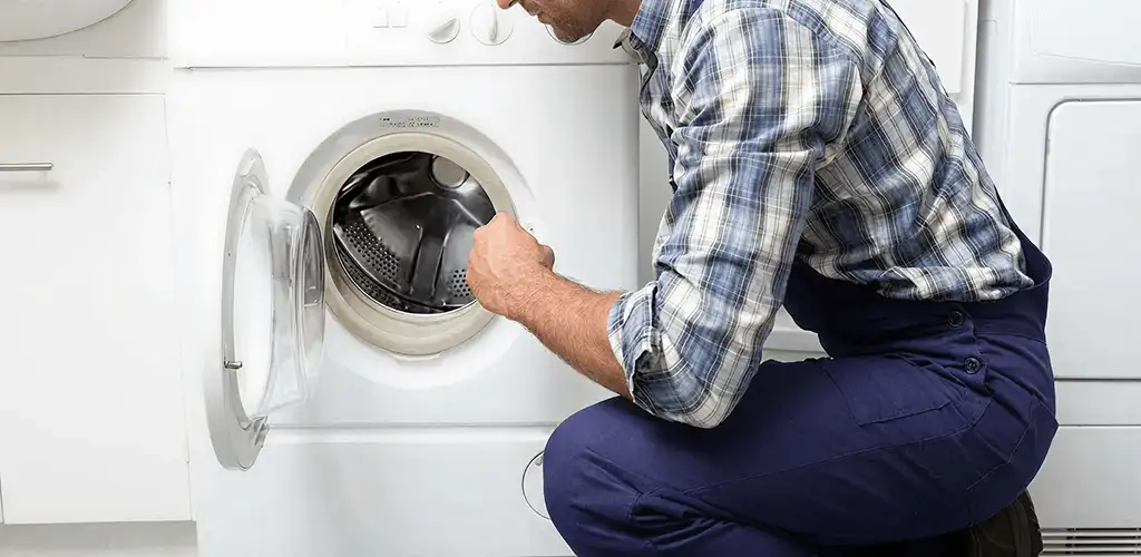 Handyman inspecting a dryer drum and internal parts for repair in Providence, RI