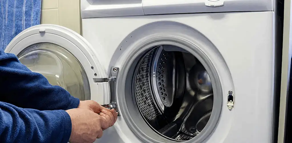 Washing machine repair handyman checking a front-load washer door and latch in Providence, RI