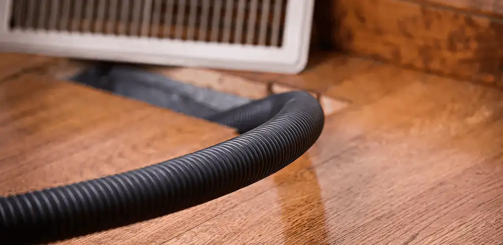 Air duct cleaning hose inserted into a floor vent for ductwork cleaning in Providence, RI