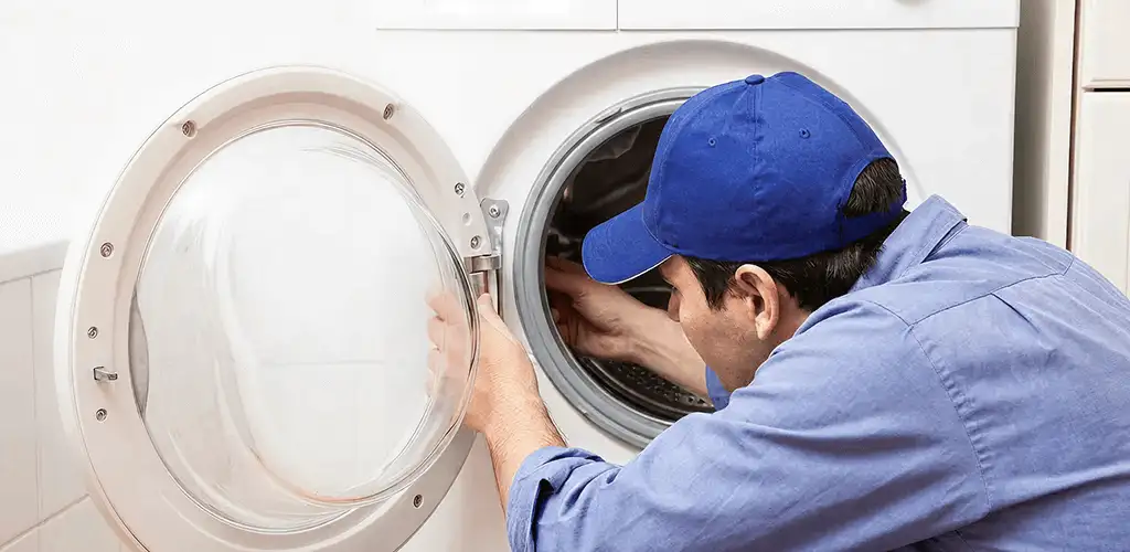 Washing machine repair handyman inspecting a front-load washer drum in Providence, RI